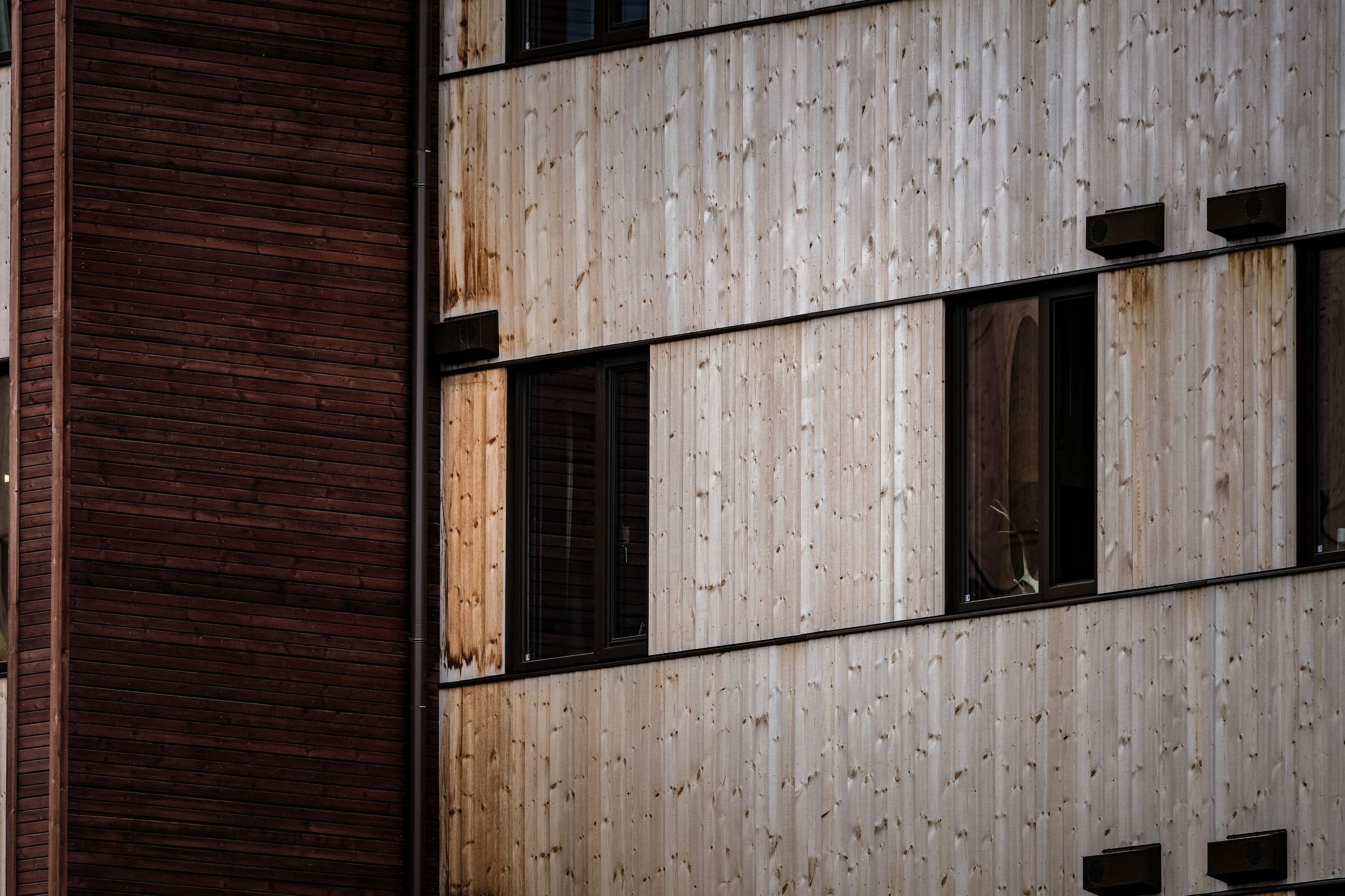 Bardage bois en lames verticales sur une façade, percement de fenêtre intégré au calepinage
