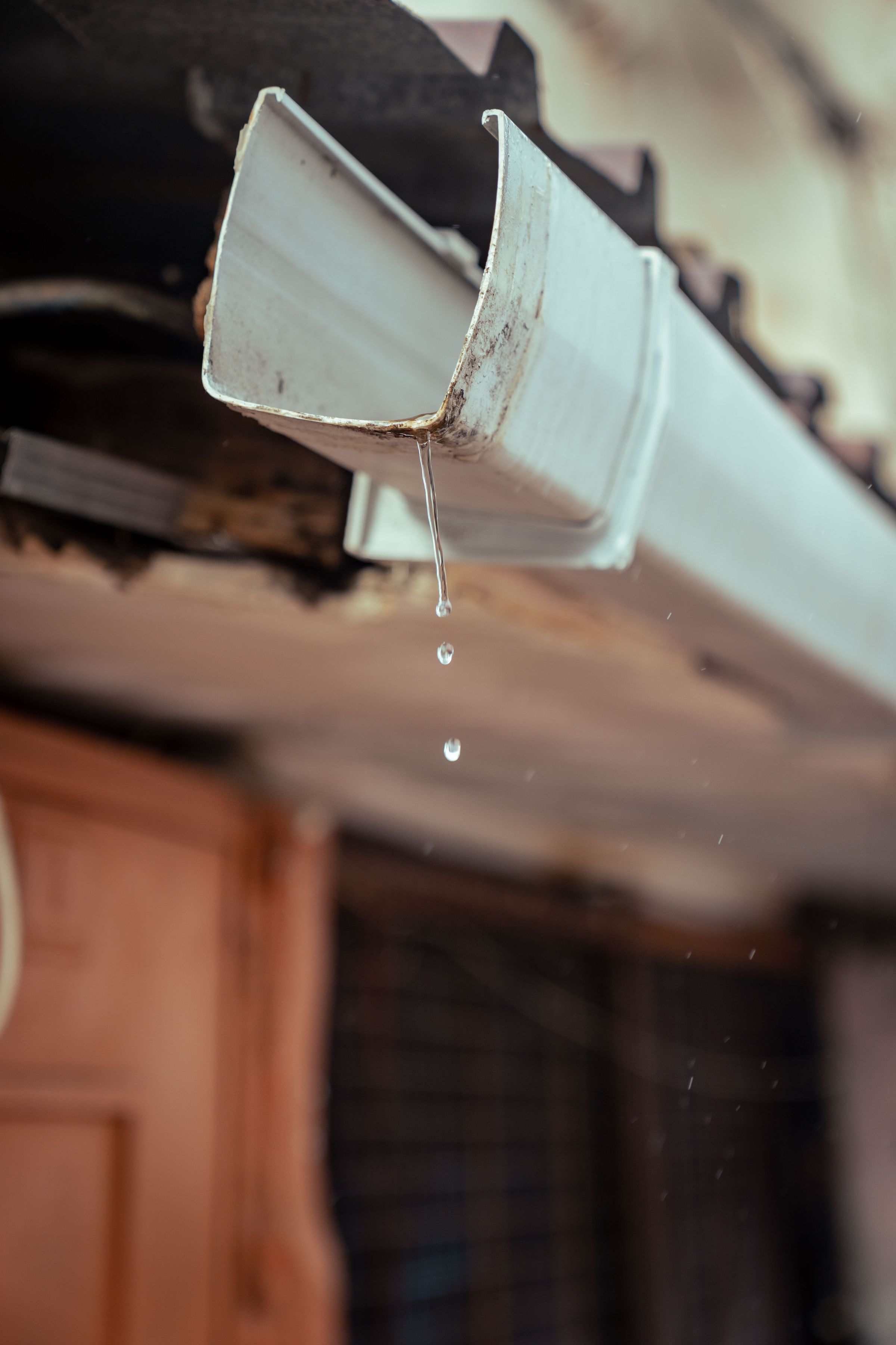 Eau de pluie s'écoulant d'une gouttière en rive de toiture